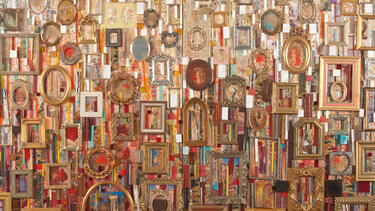 An abstract mixed media assemblage including picture frames of various colors and shapes