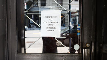 The door to a business with a sign reading "Closed due to cororavirus until further notice"