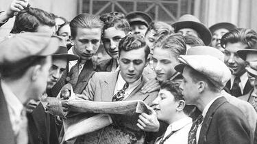 Messengers from brokerage houses crowd around a newspaper after the stock market crash on October 24, 1929. Photo: by Eddie Jackson/NY Daily News Archive via Getty Images.