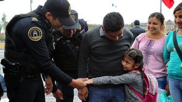 Mexican police officers greeting a family