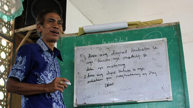 A speaker in front of a whiteboard in the Philippines