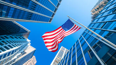 An American flag surrounded by office towers