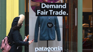 A Patagonia store with "Demand Fair Trade" and "Buy Less, Demand More" in the window.
