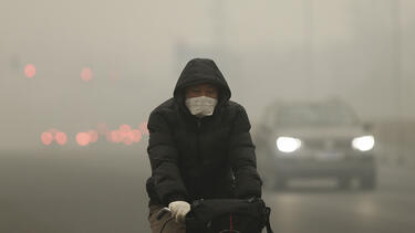 A cyclist in Beijing on a day of heavy pollution in December 2015.