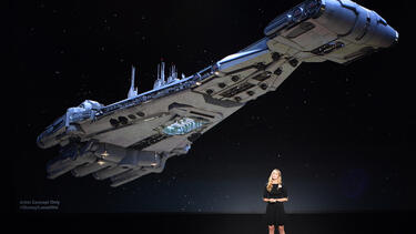 Anne Morrow Johnson standing in front of an image of a Star Wars starship