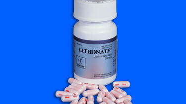 A bottle of lithium medication surrounded by capsules