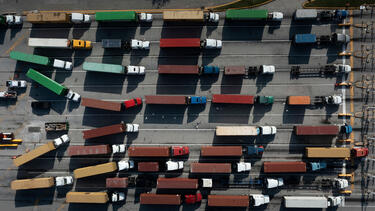 An overhead image of trucks carrying shipping containers
