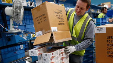 A warehouse worker unpacking a box labeled "Made in China"