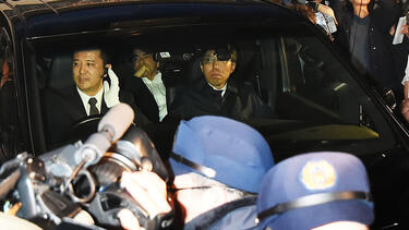 Media surround a car carrying Carlos Ghosn after he was released on bail on March 6. Photo: Jun Sato/WireImage/Getty Images.