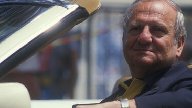 Lee Iacocca at the steering wheel of a car