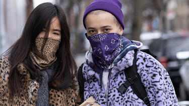 Two women wearing cloth masks color-coordinated with their clothes