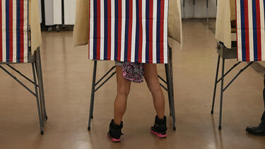 Voting booths with legs visible.