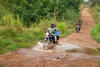 A motorcycle carrying vaccine supplies along a dirt road