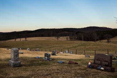 An Appalachian vista: forest, farmland, and a cemetery showing the deep family roots in this area.