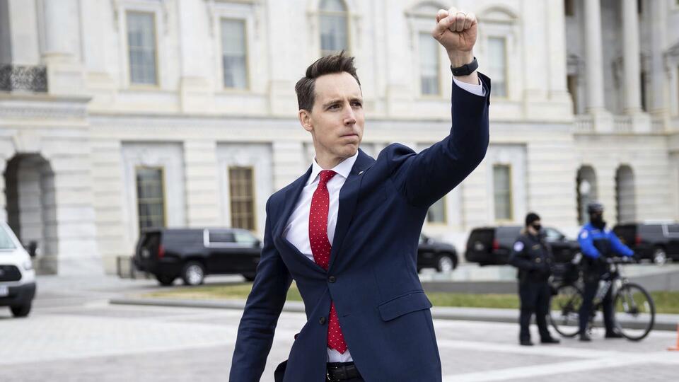 Senator Josh Hawley gestures to demonstrators as he enters the U.S. Capitol on January 6, 2021.