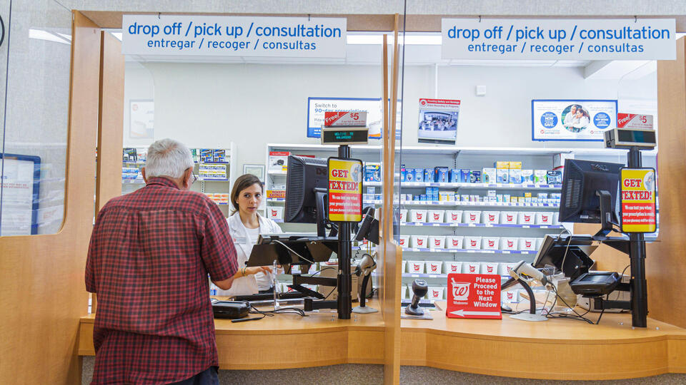 An elderly customer at a pharmacy window