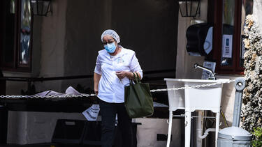 A staff member outside Fair Havens Center nursing home in Miami Springs, Florida, in May 2020. Fifty-four residents of the nursing home have died from COVID-19. Photo: Chandan Khanna/AFP via Getty Images.