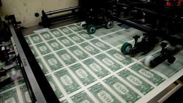 A sheet of dollar bills on a printing press