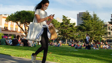 A woman looking at her phone while walking