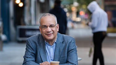 A man sitting at a table on the street in New York City