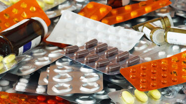 a pile of pill bottles and sheets of capsules