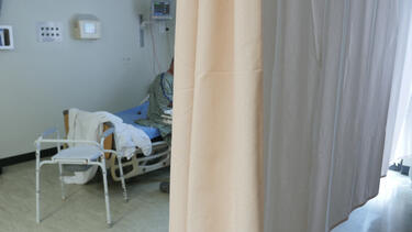 A COVID patient partly hidden by a curat Bellville Medical Center in Texas in September 2021.