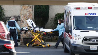 Paramedics outside the Life Care Center in Kirkland, Washington, a nursing home that experienced an early outbreak of COVID-19, on February 29, 2020.