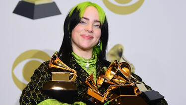 Billie Eilish with an armful of trophies at the Grammy Awards in 2020.