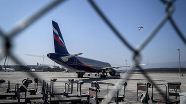 An aircraft from the Russian carrier Aeroflot seen through a fence in a long-term parking area at Geneva Airport in March 2022. 