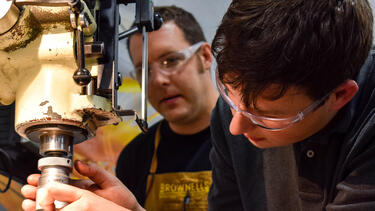 A student and instructor working with a piece of equipment