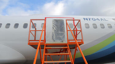 An airplane fuselage with plastic sheeting over an opening
