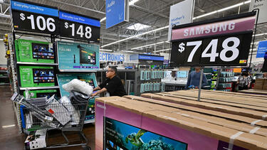 Shoppers in a chain store with televisions for sale
