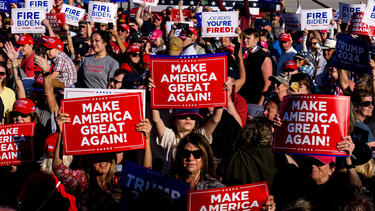 People holding "Making America Great Again" signs at a Trump rally