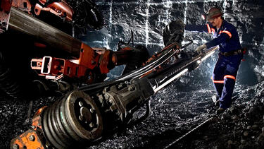 A mining engineer working with a drill in a Nevada gold mine under construction in 2004. Photo: Greenshoots Communications/Alamy Stock Photo.