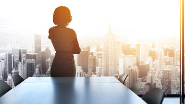 A woman in corporate boardroom overlooking New York City