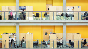 An office with desks on a series of levels connected by stairs