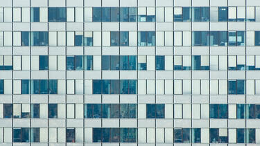 closeup of skyscraper windows showing workers busy