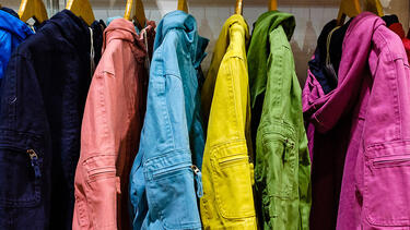 A coat rack of jackets of different colors.