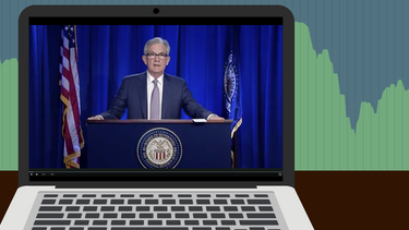 An illustration of Fed chair Jerome Powell speaking on a laptop in front of a stock chart