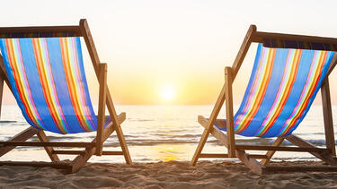 Beach chairs on a beach at sunset