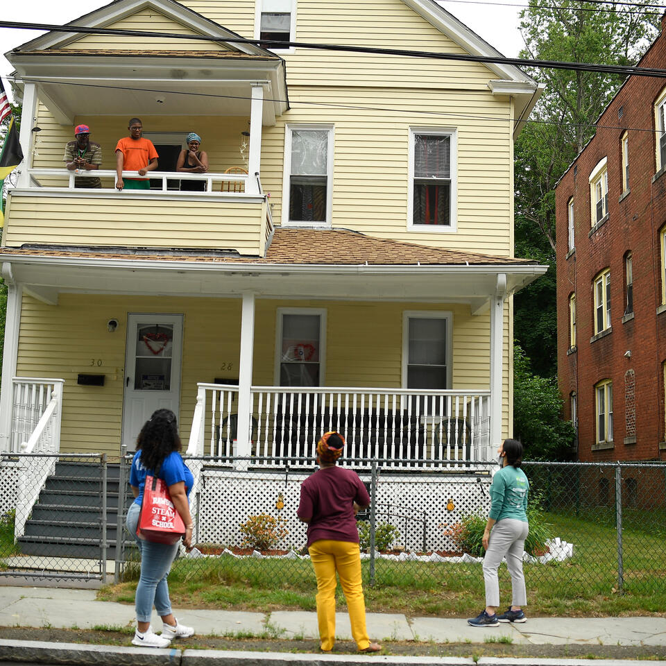 Hartford Public Schools Superintendent Leslie Torres-Rodriguez (bottom right) and other school leaders talk with a family on their second-floor porch in the district in June 2020. AP Photo/Jessica Hill.