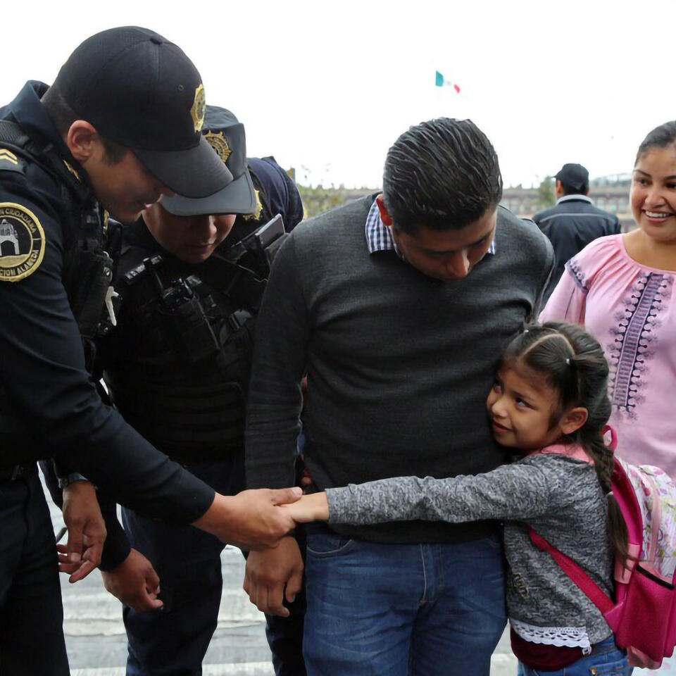 Mexican police officers greeting a family