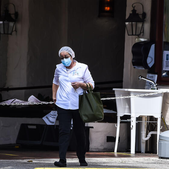 A staff member outside Fair Havens Center nursing home in Miami Springs, Florida, in May 2020. Fifty-four residents of the nursing home have died from COVID-19. Photo: Chandan Khanna/AFP via Getty Images.
