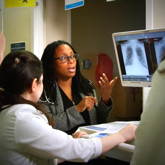 Doctors gathered around an x-ray on a computer screen