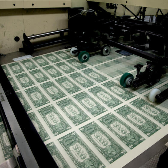 A sheet of dollar bills on a printing press