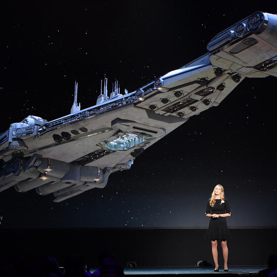 Anne Morrow Johnson standing in front of an image of a Star Wars starship
