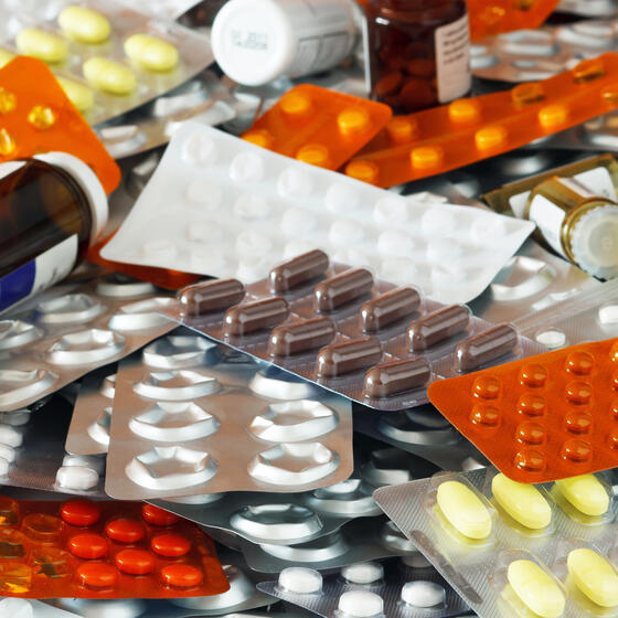 a pile of pill bottles and sheets of capsules