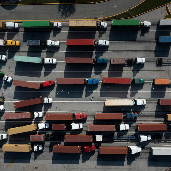 An overhead image of trucks carrying shipping containers
