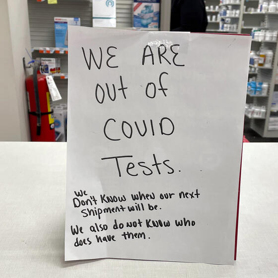 A sign at a drugstore reading "We are out of COVID tests. We don't know when our next shipment will be. We also do not know who does have them."