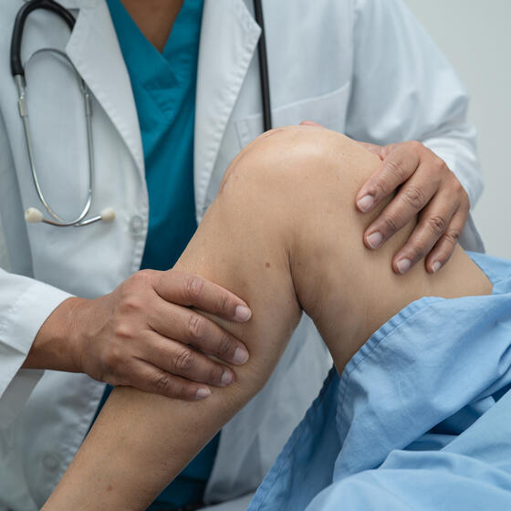 A closeup of a doctor examining a knee
